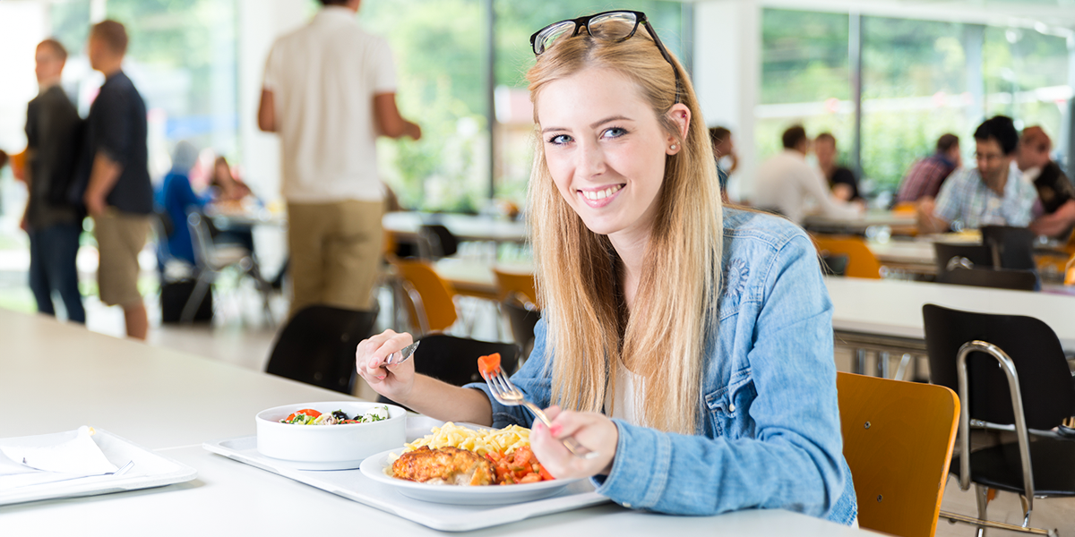 Young student eats in canteen